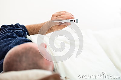 Dramatic image of a sick man laying in bed with fever Stock Photo