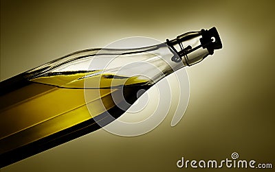 Warm light glows through virgin olive oil in a transparent glass bottle Stock Photo