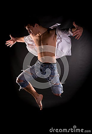 Dramatic light photo of modern acrobat jumping Stock Photo