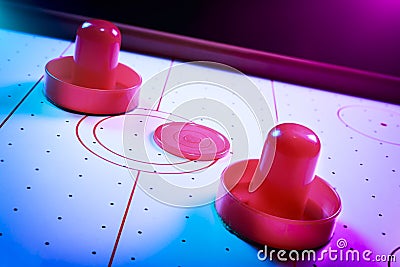 Dramatic lit air hockey table with puck and paddles Stock Photo