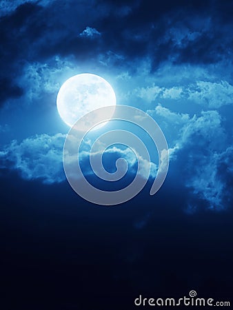 Dramatic Moonrise Background With Deep Blue Nightime Sky and Clouds Stock Photo