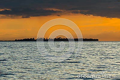 Dramatic orange tinged Sunset in the Bohol Strait. Silhoutte of Bugatusan Island, a small inhabited islet off the town of Inabanga Stock Photo