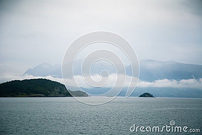 A dramatic, overcast scenery on the coeast of fjord during a ferry ride in Norway near Bergen. Stock Photo