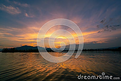 Dramatic panorama evening sky and clouds over mountain and lake at sunset Stock Photo