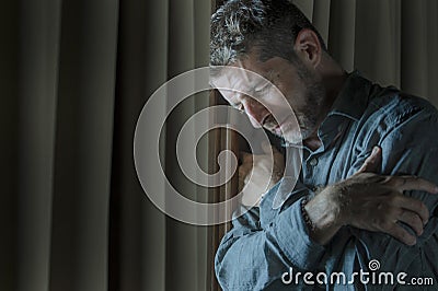 Dramatic portrait of depressed and sick man suffering from psychosis illness or mental disorder looking weird and helpless in Stock Photo