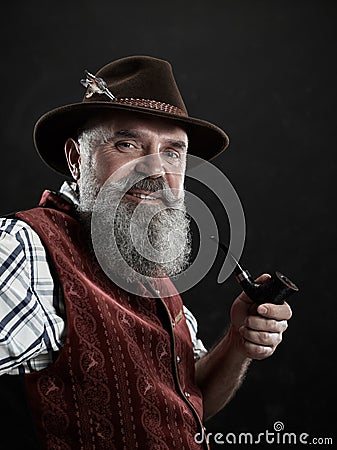 Dramatic portrait of senior smoking tobacco pipe Stock Photo