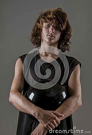 Dramatic portrait of a tough biker kid holding motorcycle helmet Stock Photo