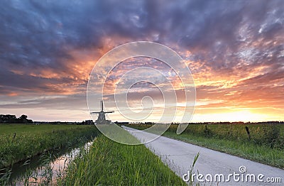 Dramatic purple sunset in Dutch countryside with windmill Stock Photo
