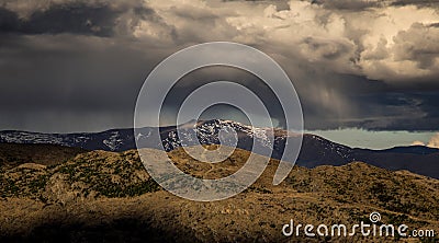 Dramatic rain storm cloud form over the snow mountain Stock Photo