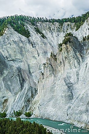 Dramatic and Rugged Rocky Mountains Cliffs with Green Forest and Stock Photo