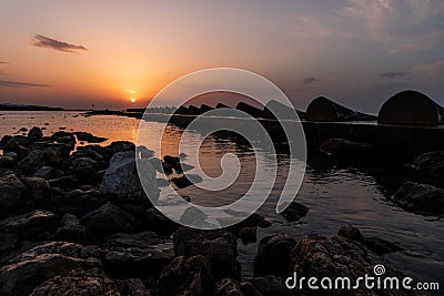 Orange to grey twilight over a rocky Spanish bay Stock Photo