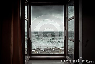 Dramatic sea view from opened window with big stormy waves and dramatic sky during rain and storm weather in fall season on sea co Stock Photo