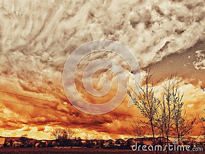 Dramatic sky with upcoming bad weather and black clouds as the sun goes through the clouds and creates the wonderfully colorful sk Stock Photo