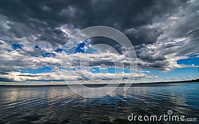 Dramatic spring storm clouds over the lake Stock Photo