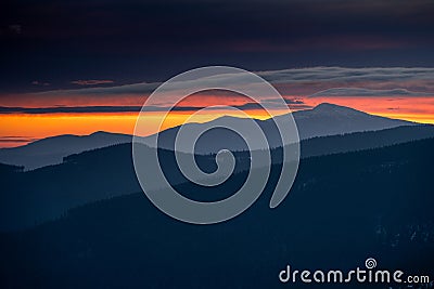 Dramatic sunrise in Beskids Mountains. View from Rysianka mountain to Babia Gora peak on the fire red sky Stock Photo