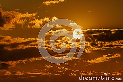 Dramatic sunset with clouds. The round sun sits down Stock Photo