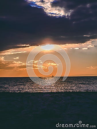Dramatic sunset near the seaside - industrial structure on the horizon Stock Photo