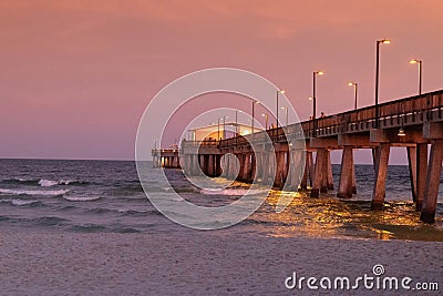 Dramatic sunset over the Gulf State Park Pier silhouetting a picturesque shoreline Stock Photo