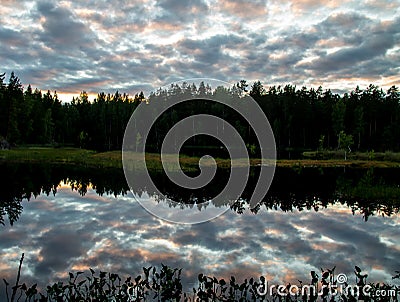 Dramatic sunset reflecting on a pond Stock Photo