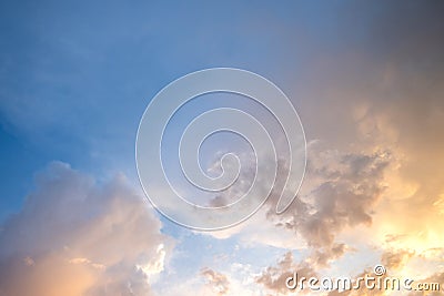 Dramatic sunset sky landscape with puffy clouds lit by orange setting sun and blue heavens Stock Photo