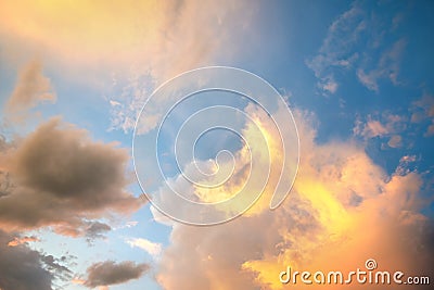 Dramatic sunset sky landscape with puffy clouds lit by orange setting sun and blue heavens Stock Photo