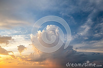 Dramatic sunset sky landscape with puffy clouds lit by orange setting sun and blue heavens Stock Photo