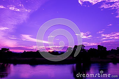 Dramatic sunset in sky and reflect river beautiful colorful tone blue- purple landscape silhouette tree woodland twilight time wit Stock Photo