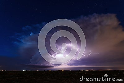 Supercell storm clouds illuminated by lightning strikes Stock Photo