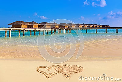 Drawing connected hearts on beach Stock Photo