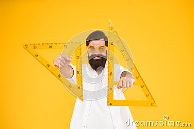 For drawing, draughting and design. Hipster holding drawing instruments on yellow background. Architect and engineer Stock Photo