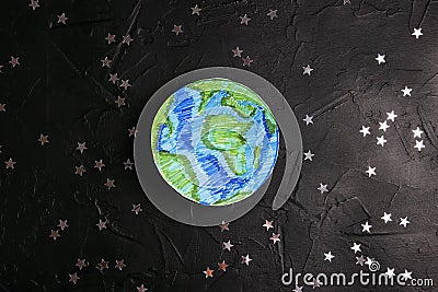 Drawn planet Earth among the stars on a black background. Science, ecology, environmental protection Stock Photo