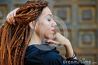 Dreadlocks closeup, fashionable girl posing at old wooden door background Stock Photo