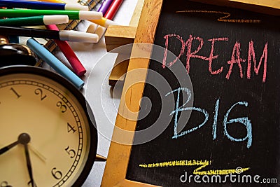 Dream big on phrase colorful handwritten on chalkboard, alarm clock with motivation and education concepts Stock Photo