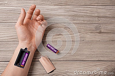 Dream gives strength and energy moves on. Word my dream is written on the battery. Hand of man with a slot for charging batteries Stock Photo