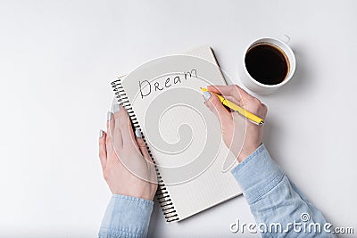 DREAM handwritten text on copybook. Female hand writing in notebook Stock Photo