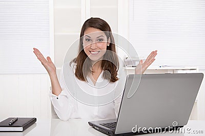 Dream job: successful smiling businesswoman sitting at desk with Stock Photo