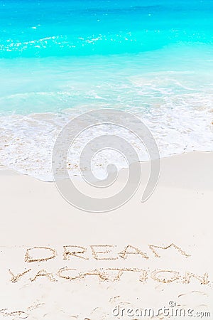 Dream written on sandy beach with soft ocean wave on background Stock Photo