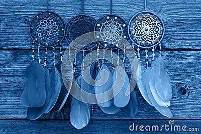 Dreamcatcher made of feathers, leather, beads, and ropes in classic blue trendy color of the year 2020 Editorial Stock Photo