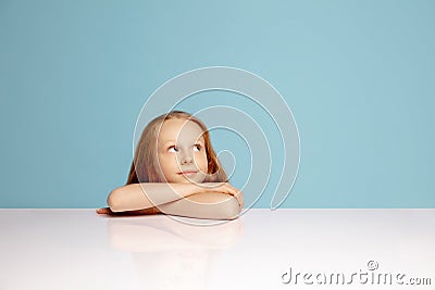 Happy redhair girl isolated on blue studio background. Looks happy, cheerful, sincere. Copyspace. Childhood, education Stock Photo