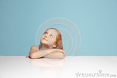 Happy redhair girl isolated on blue studio background. Looks happy, cheerful, sincere. Copyspace. Childhood, education Stock Photo