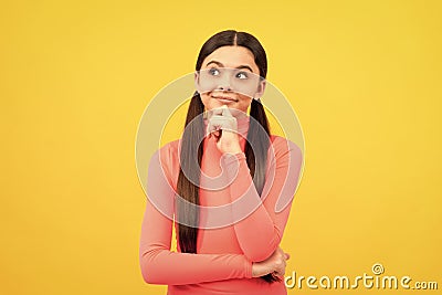 dreaming child with long hair on yellow background, daydreamer Stock Photo