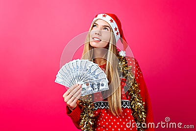Dreaming girl in a red sweater and a hat of Santa Claus, makes p Stock Photo