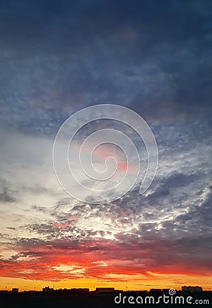 Dreamlike colorful sunset over the city horizon, vertical celestial background Stock Photo