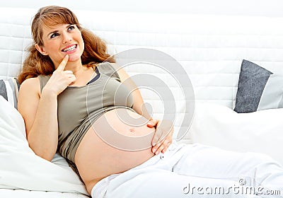 Dreams pregnant woman sitting on sofa at home Stock Photo