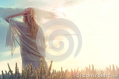 Dreamy and beautiful woman looks at infinity as the sun rises Stock Photo