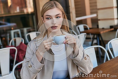 dreamy blonde woman in trench coat Stock Photo