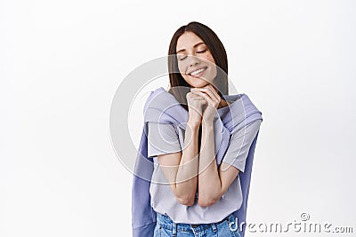 Dreamy caucasian woman daydreaming, close eyes and thinking about something beautiful, feel nostalgic, remember Stock Photo
