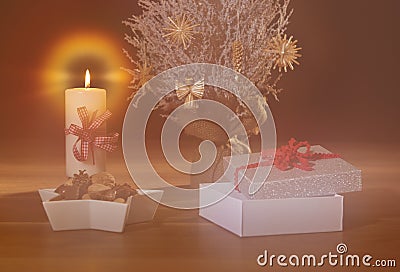 Dreamy Christmas background with snow covered tree, straw decorations, burning candle and open present Stock Photo