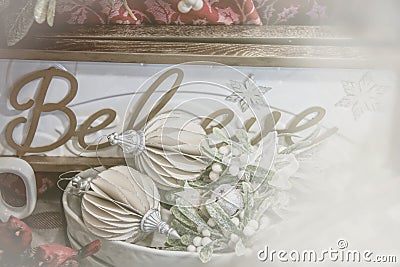 Dreamy filtered Christmas Holiday background with ornate ornaments glittery mistletoe piled in front of a sign that says believe Stock Photo