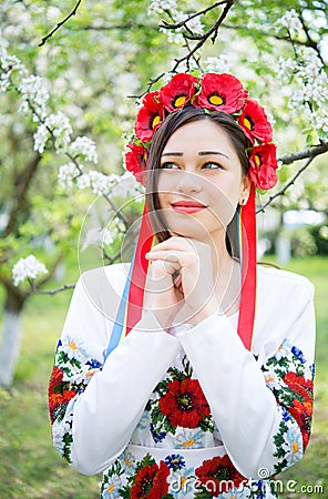 Dreamy girl in national clothes in a flowering garden Stock Photo